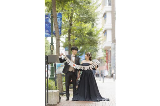 「JUST MARRIED」ガーランドを掲げて楽しそうに