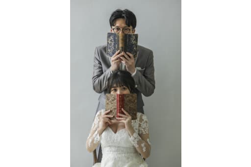 本で口元を隠して