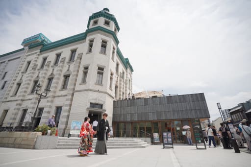趣ある建物の前で