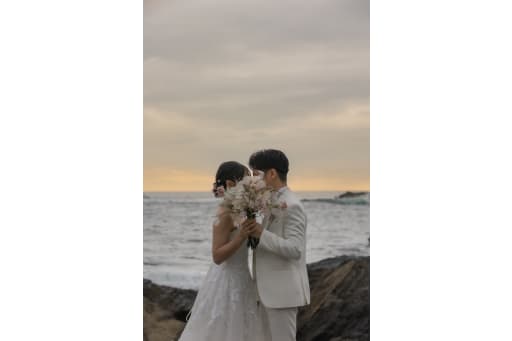 サンセットの海辺で、ブーケ越しに