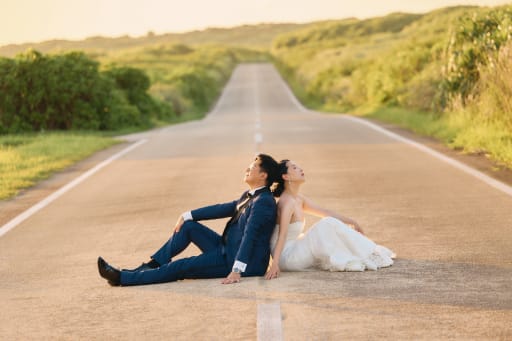 見晴らしの良い道路で背中合わせに座るお二人