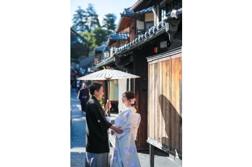 まず、京都らしい街並みの中で、一つの和傘の下に寄り添うお二人のカット