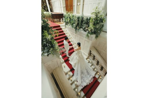 王道な階段でのエスコート写真 緑と赤い絨毯も相まって素敵ですね♪
