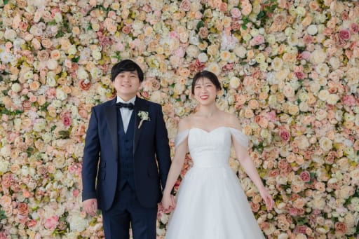 お花の壁の前で