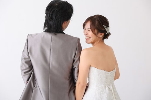 新郎さまの背中に寄り添い、こぼれる笑顔