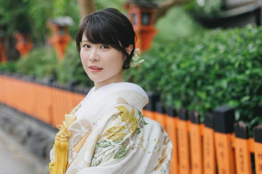 新婦様のソロカットでは、祇園の街の朱色が白い打掛を美しく引き立てています。