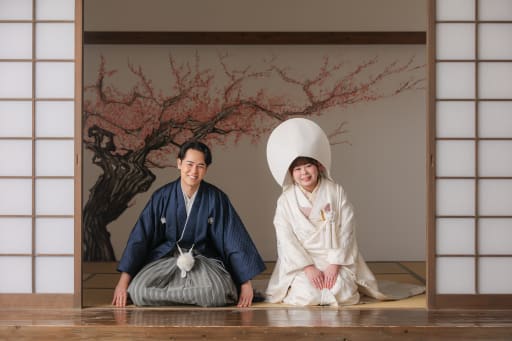 桜の壁画の前で並んで座り丁寧にご挨拶