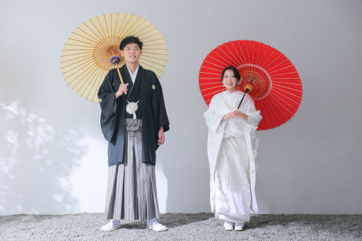 赤と生成りの和傘が彩る立ち姿