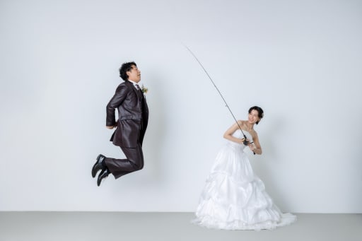 釣り竿を手にした新婦様がグッと竿を引くと……なんと新郎様が空へ大ジャンプ！ タイミングもバッチリで、まるで本当に釣られてしまったかのような臨場感たっぷりのアートな1枚が完成しました。
