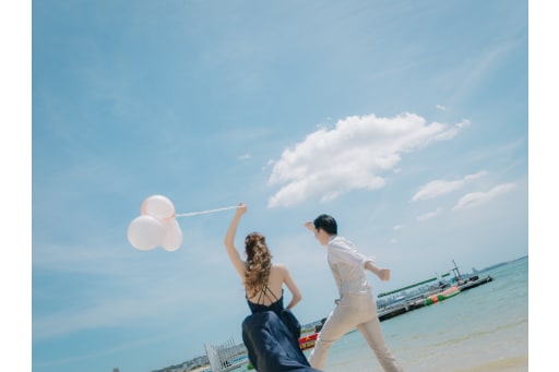 バルーンを掲げて砂浜を走る一コマ