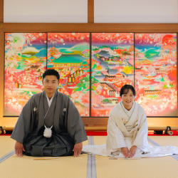 華やかな屏風の前で