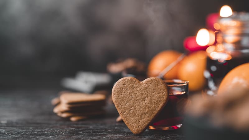 Pepparkaka framf�r en mugg med gl�gg. Pepparkakor och apelsin i bakgrunden
