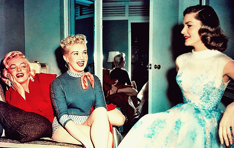 How To Marry a Millionaire cast. Marilyn Monroe and Betty Gable look at Lauren Bacall, and they are laughing and having a good time on set.