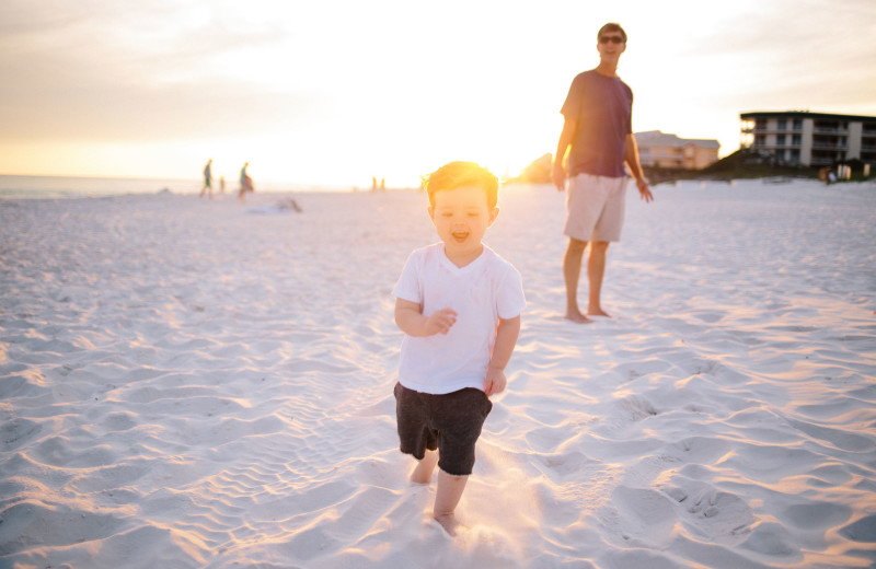 Family on beach at Harris Properties Management.