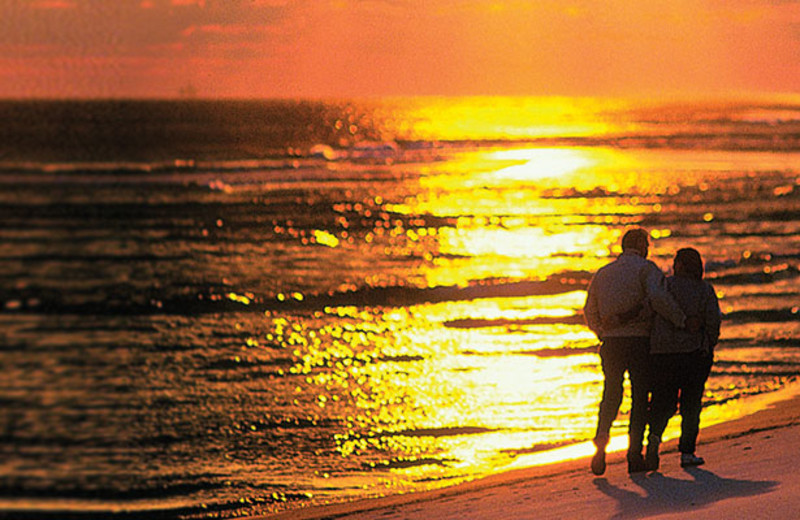 Couple walking on beach at ACP Vacation Rentals.