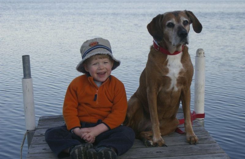 Kid and dog on dock at Cozy Bay Resort.
