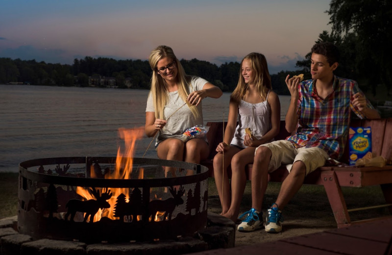 Family at bonfire at Delton Oaks Resort.