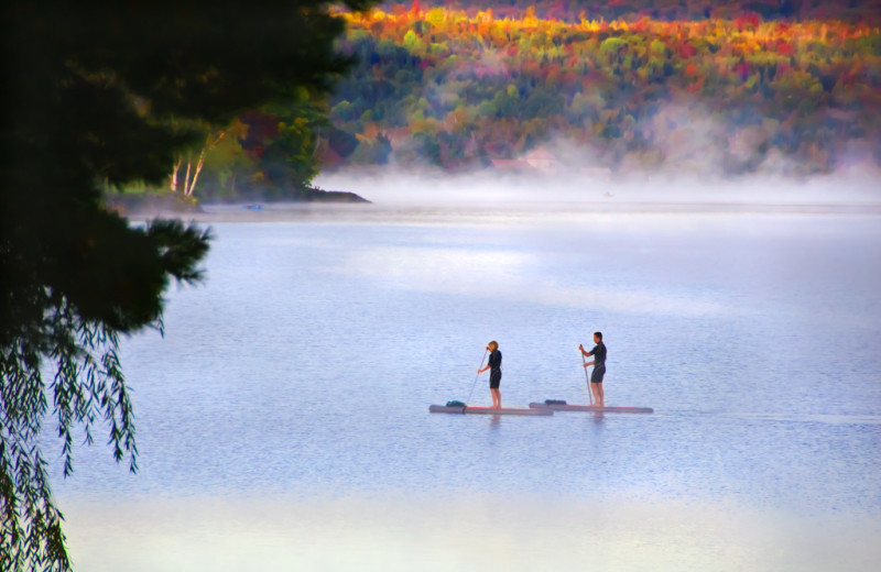 Spectacular peak fall foliage and pristine international Wallace Pond provide the perfect setting for stand-up paddle boarding of the sandy beach at Jackson's Lodge, Canaan, Vermont's Northeast Kingdom.