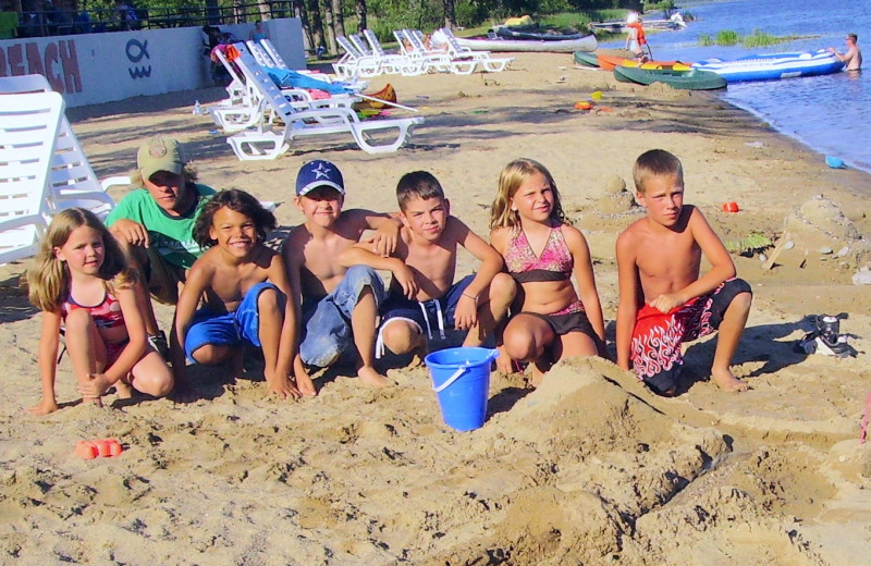 Family on beach at Hiawatha Beach Resort.
