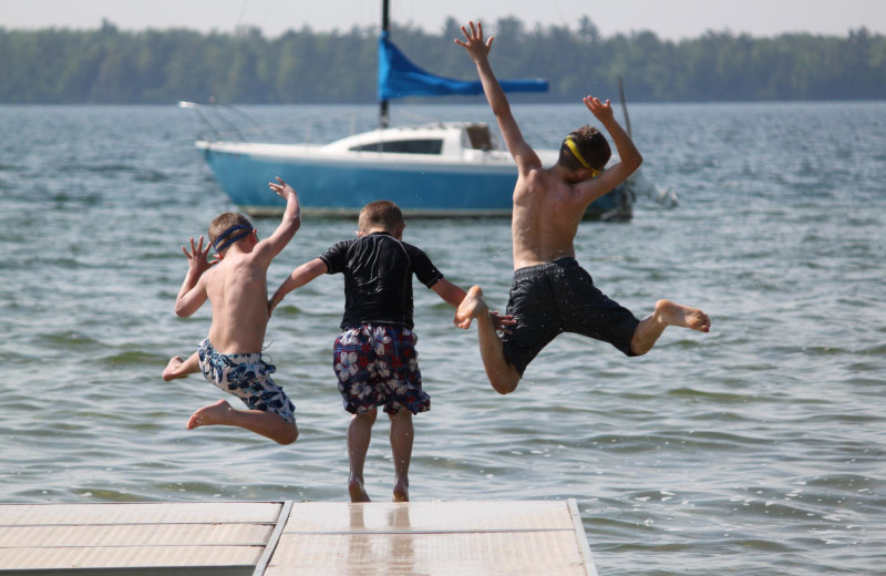 Jumping in the lake at Visit Up North Vacation Rentals.