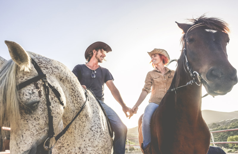 Couple horseback riding at Red Horse Mountain Ranch.