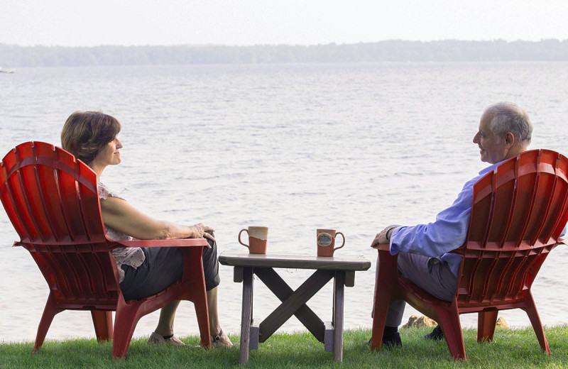 Couple by lake at The Lake House at Ferry Point B&B.
