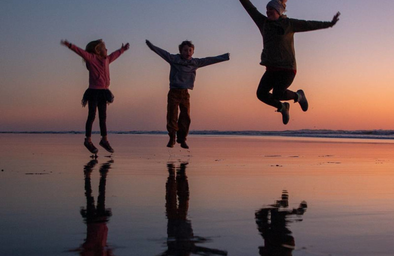 Family on beach at Bloomer Estates Vacation Rentals.