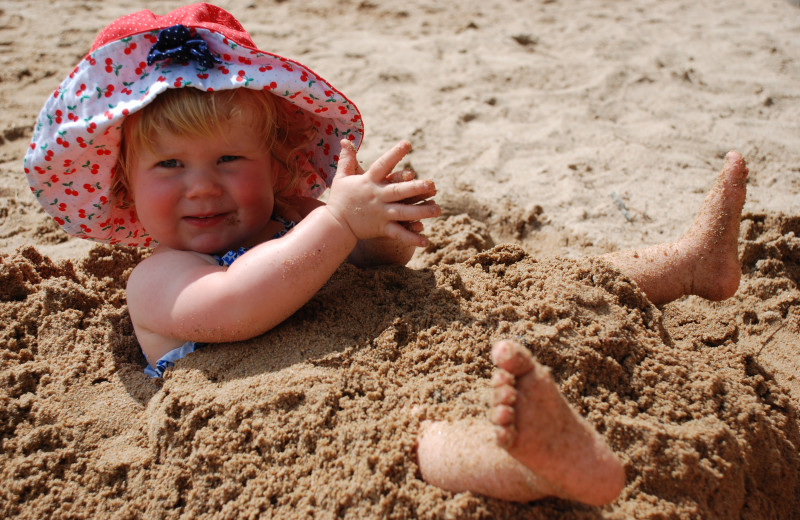 Kid in sand at YMCA Camp Du Nord.