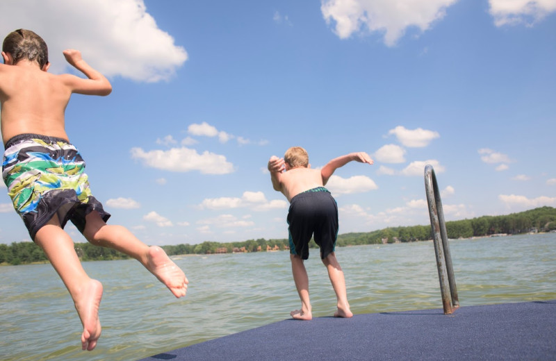 Jumping in lake at Delton Oaks Resort.