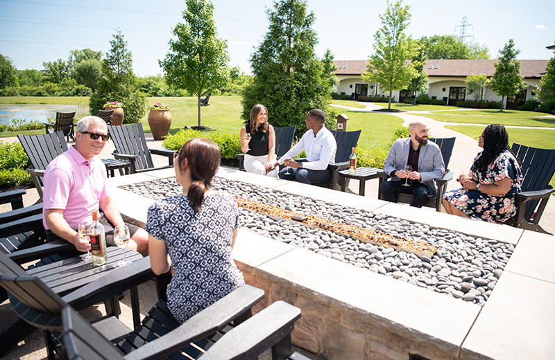 A family sitting outside while enjoying libations and conversation.