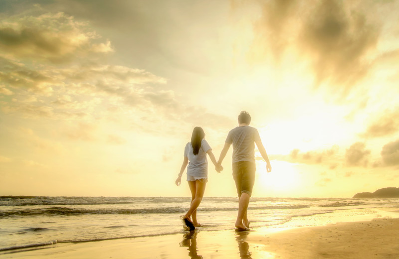 Couple walking on beach at CNE Vacation Rental.