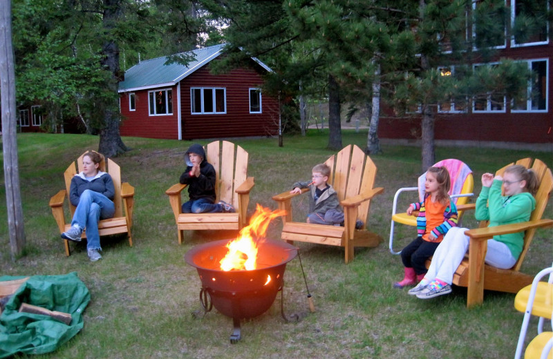 Family by the fire pit at Two Inlets Resort.