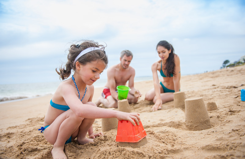 Family making sandcastles at Ocean Walk Hotel.