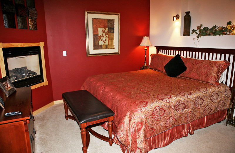 Vacation rental bedroom with fireplace at Marys Lake Vacation Condos.