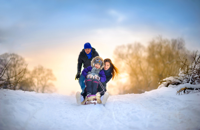 Family sledding at Finger Lakes Premiere Properties.