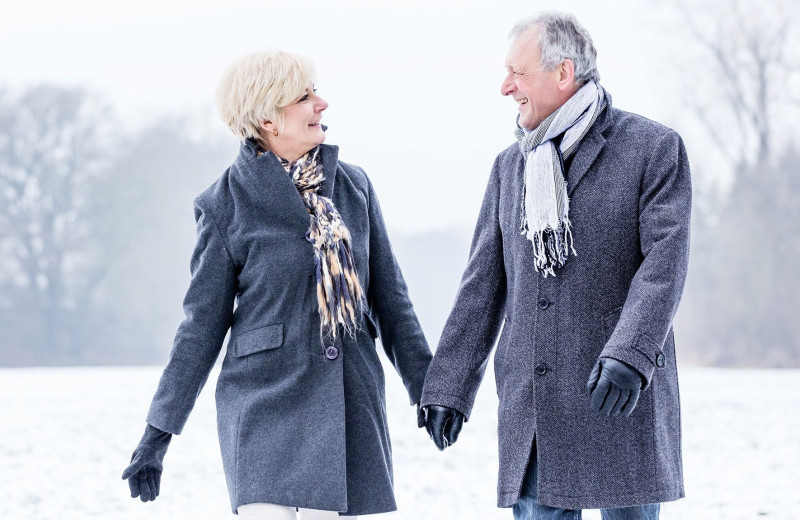 Couple walking in snow at Villa Roma Resort and Conference Center.