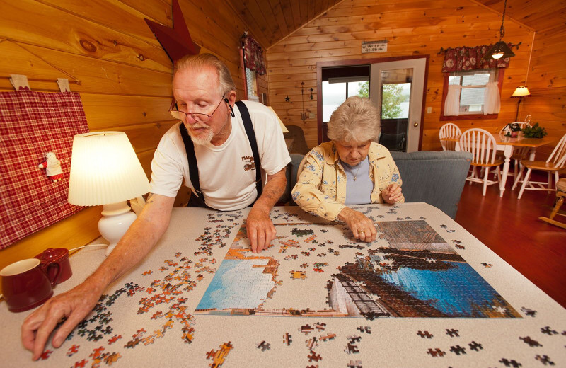 Family puzzle-time in a meticulously clean country-style decorative lakeside cabin at Jackson's Lodge and Log Cabin Village, Canaan, Vermont's Northeast Kingdom.