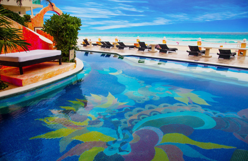 Outdoor pool and beach at Hotel Mía Cancún.