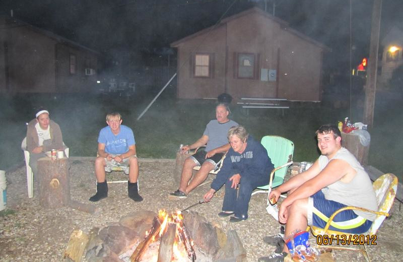 Family around campfire at Black Hills Cabins & Motel at Quail's Crossing.