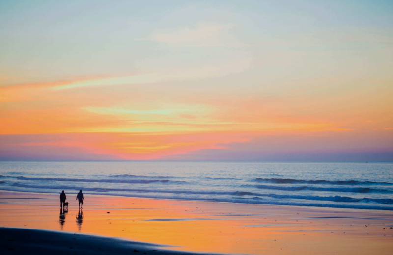 Couple walking on beach at Outer Beaches Realty.