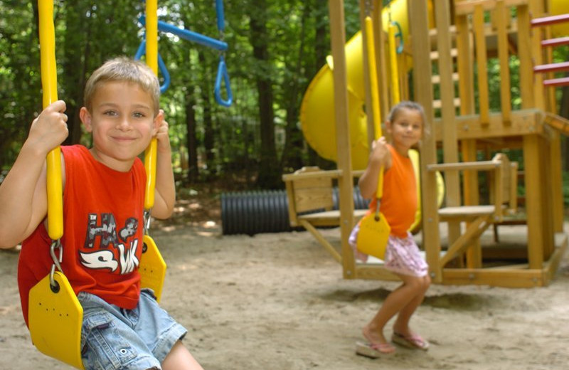 Kids playing on playground at Hemlock Campground & Cottages.