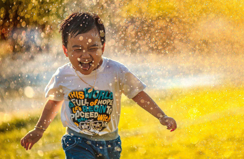 Kid running through water at Owl's Nest Resort & Golf Club.