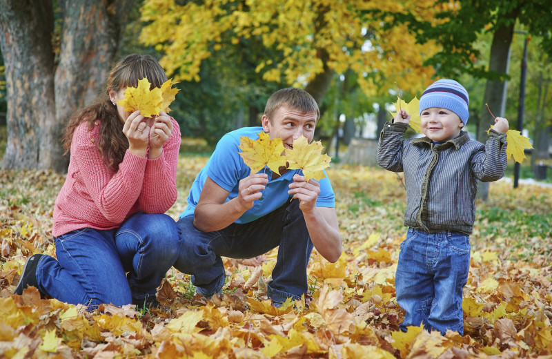 Family playing in leaves at Patterson Kaye Resort.