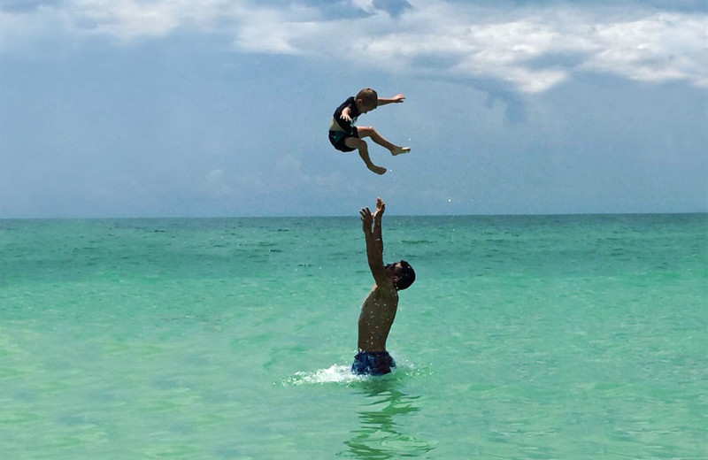 Family swimming at beach at beachrentals.mobi. LLC.