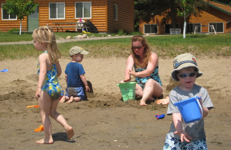 Family playing at the beach at Cozy Bay Resort.