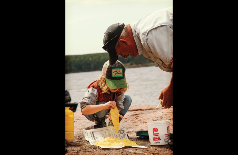 Kid dipping fish in batter at Tetu Island Lodge.