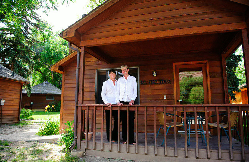 Couple by cabin at Sylvan Dale Guest Ranch.