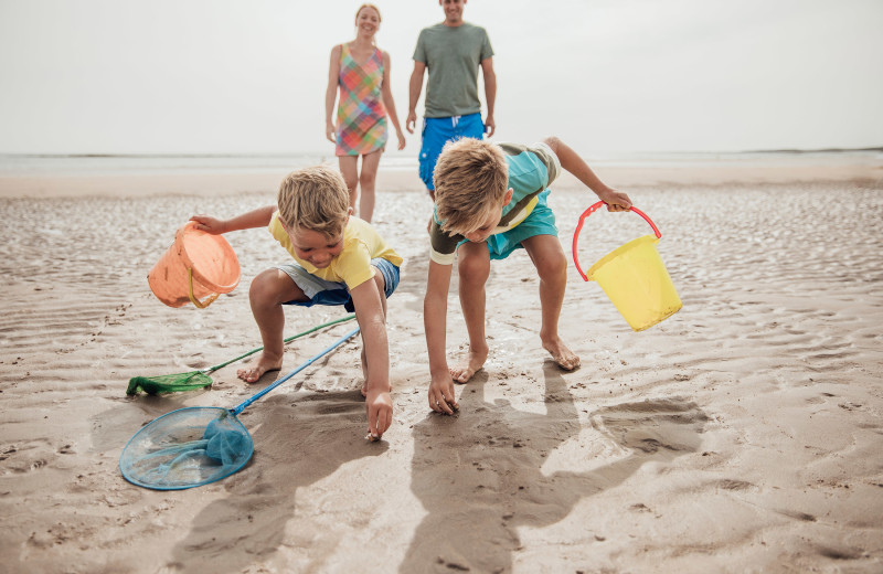 Family on beach at Pirate's Cove Realty.