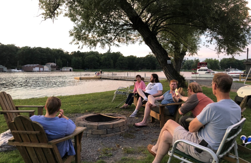 Family gathered by bonfire at Pinehurst Motel & Cottages.