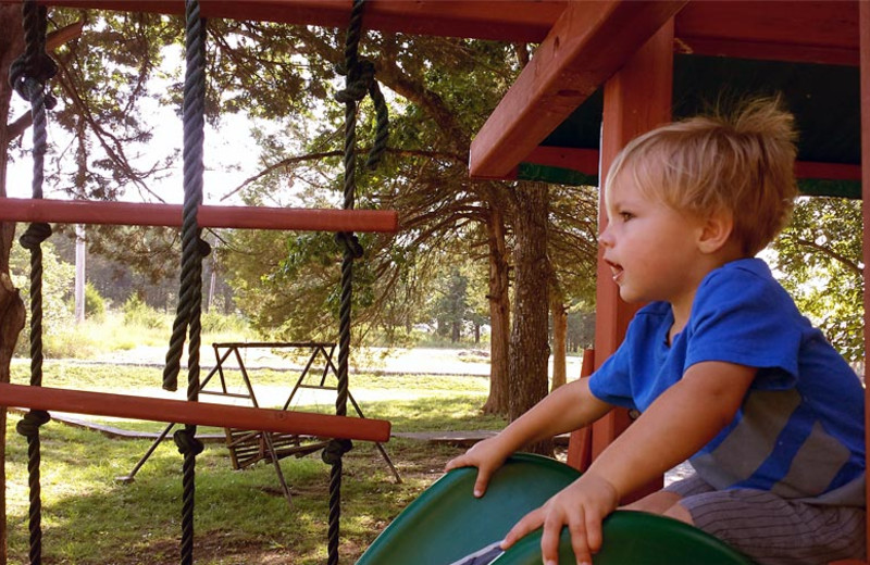 Kid on playground at Golden Arrow Resort.